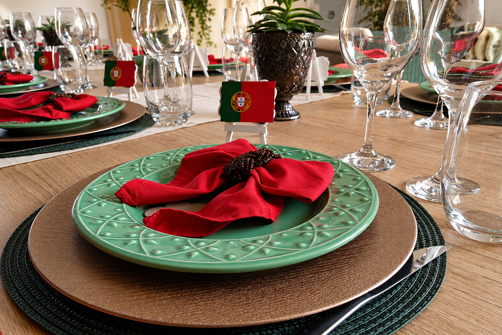 Mesa de jantar portuguesa com louças verdes e guardanapos vermelhos